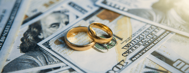 Wedding rings placed on top of money