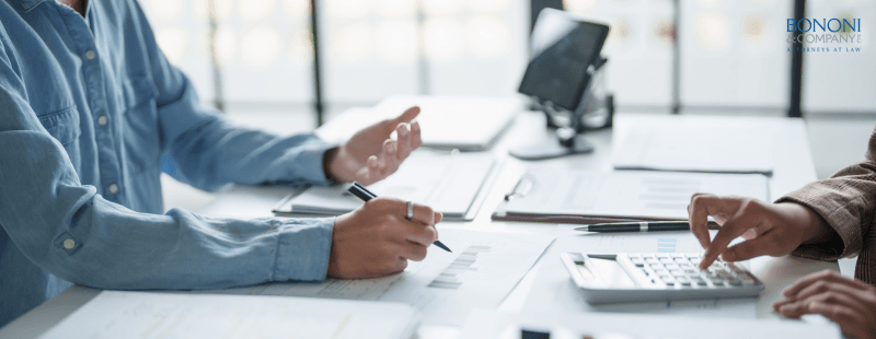 attorney talking with client at a desk reviewing retirement accounts in a divorce