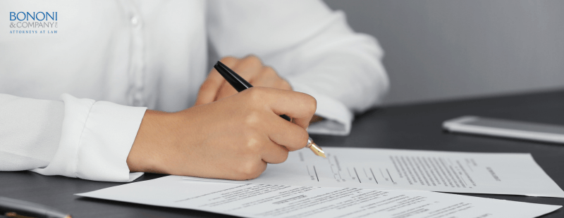 man sitting at a table signing documents